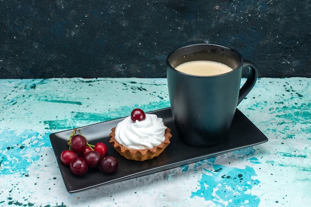 little cake with cream and cherries along with milk on dark-blue, fruit cake pie sweet cream