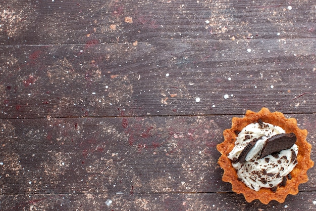 Piccola torta con crema e cioccolato isolato su legno marrone rustico, torta biscotto dolce cuocere