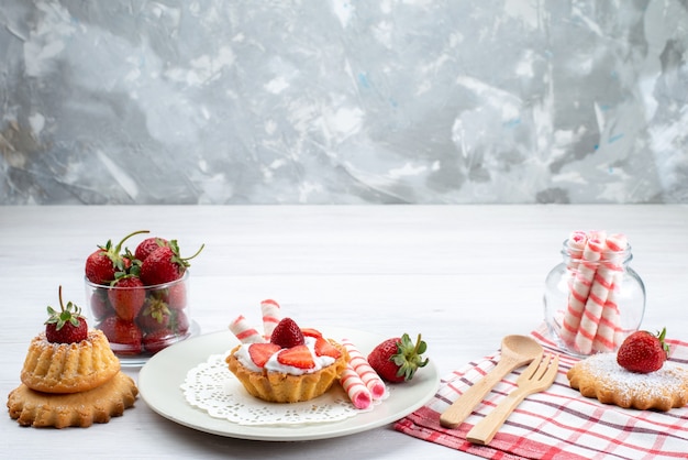 маленький торт со сливками и нарезанной клубникой, торты, конфеты на белом столе, фруктовый торт, ягодный сахар