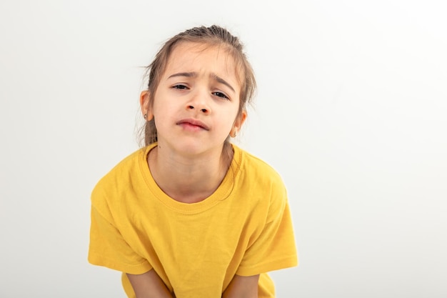 Little caucasian girl looks dissatisfied on a white background isolated