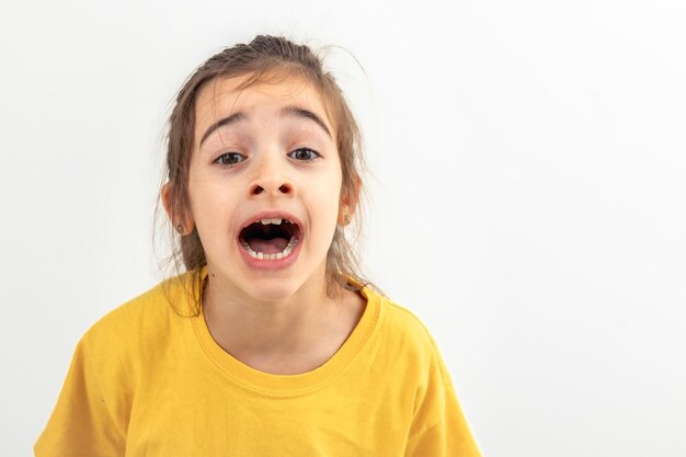 A little caucasian girl screams loudly isolated on white background