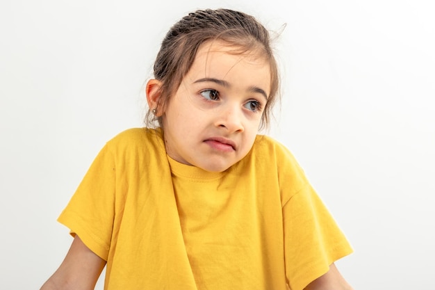 Free photo little caucasian girl shyly posing on white background