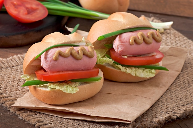 Foto gratuita piccolo hot dog allegro con salsiccia e pomodoro