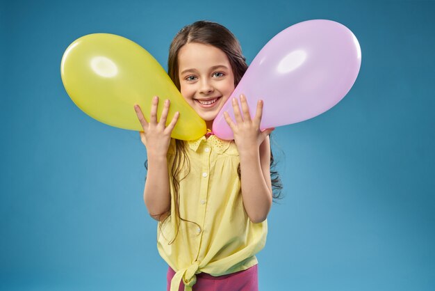 Little cheerful model posing with balloons.