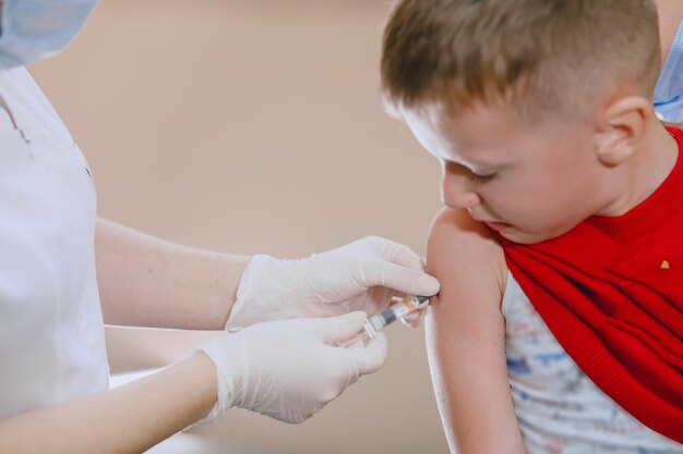 Little child medical visit. Doctor giving a child injection in arm.