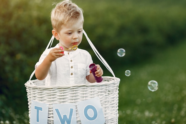 Little child sitting in the basket with balloons