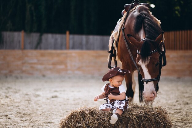 Little cowboy sitting on hay