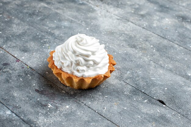 灰色の机の上に隔離されたおいしい焼きたての小さなクリーミーなケーキ、ケーキビスケット甘い砂糖クリーム