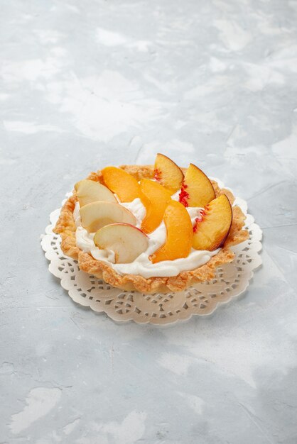 하얀 빛 책상에 얇게 썬 과일이 달린 작은 크림 케이크, 과일 케이크 달콤한 비스킷 쿠키 맛