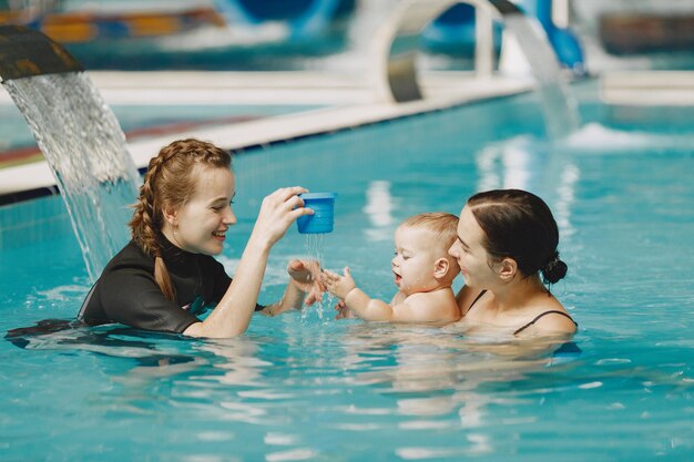 Little cute baby boy. Instructor with kid. Mother with son