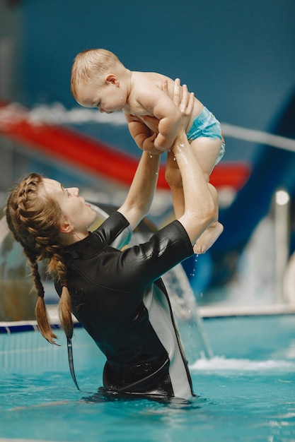 Little cute baby boy. Instructor with kid. Mother with son