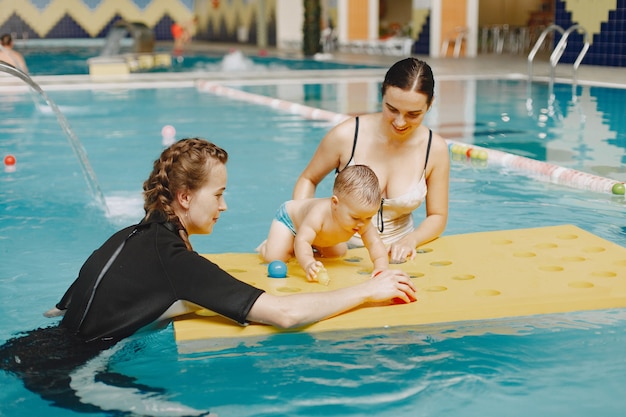 Little cute baby boy. Instructor with kid. Mother with son