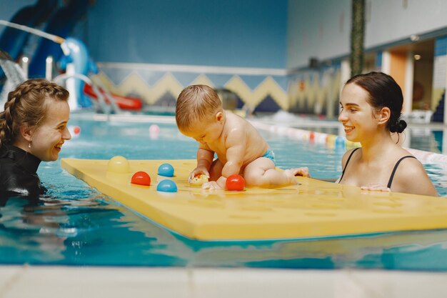 Little cute baby boy. Instructor with kid. Mother with son