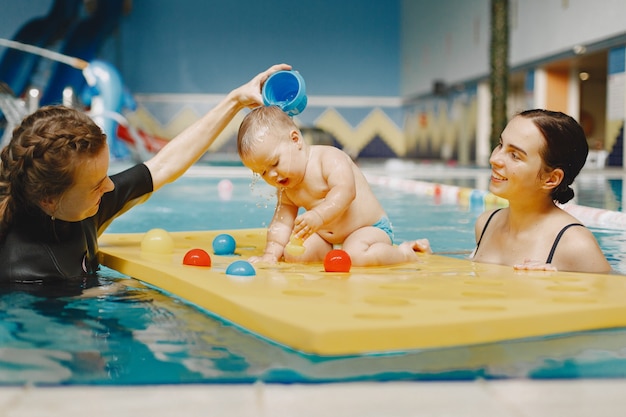 Little cute baby boy. Instructor with kid. Mother with son