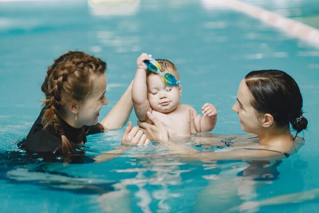 Little cute baby boy. Instructor with kid. Mother with son