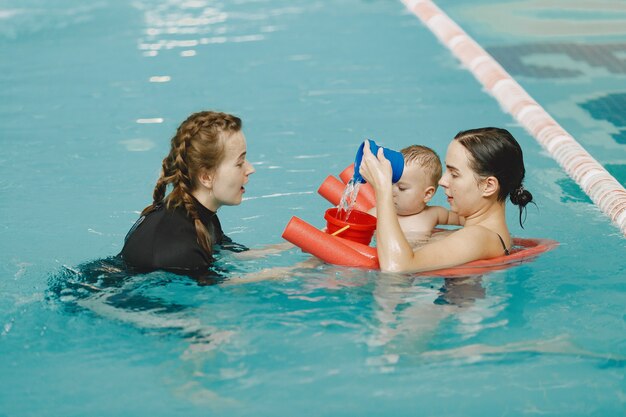 Little cute baby boy. Instructor with kid. Mother with son