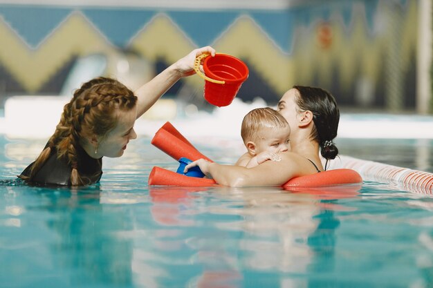 Little cute baby boy. Instructor with kid. Mother with son