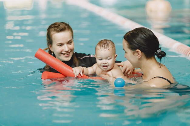 Little cute baby boy. Instructor with kid. Mother with son