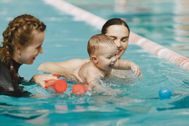 Little cute baby boy. Instructor with kid. Mother with son