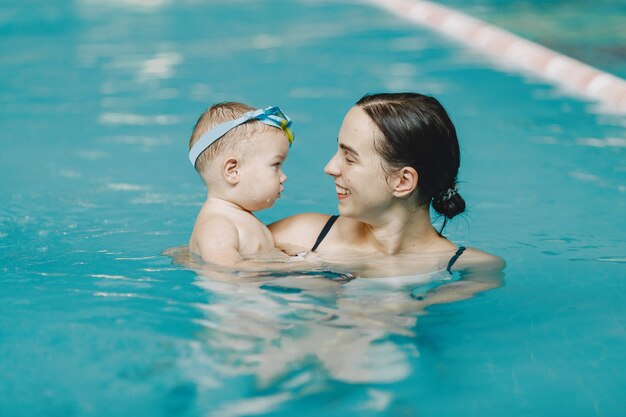 Маленький милый мальчик. Мать с сыном. Семья играет в воде