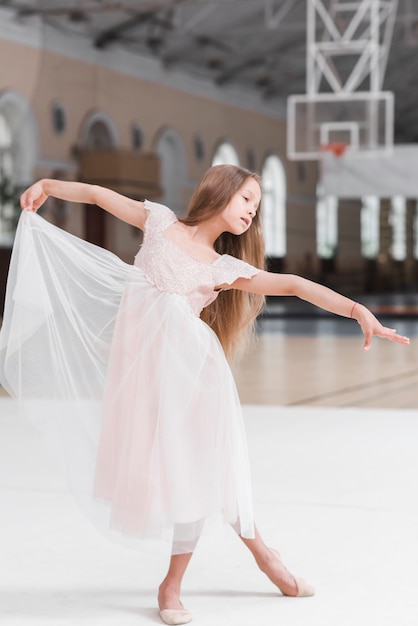 Маленькая девочка милая балерина, танцующая на полу