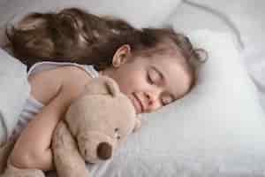 免费的照片可爱的小女孩在床上的玩具