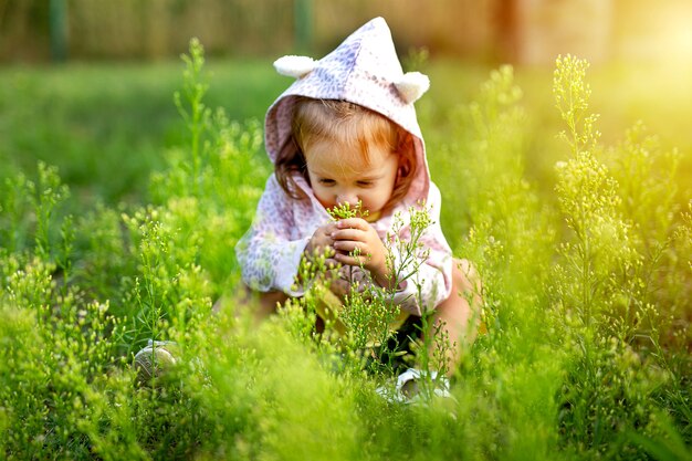 Little cute girl playing on the field of grass