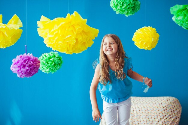 Little cute girl playing with colored flowers indoors