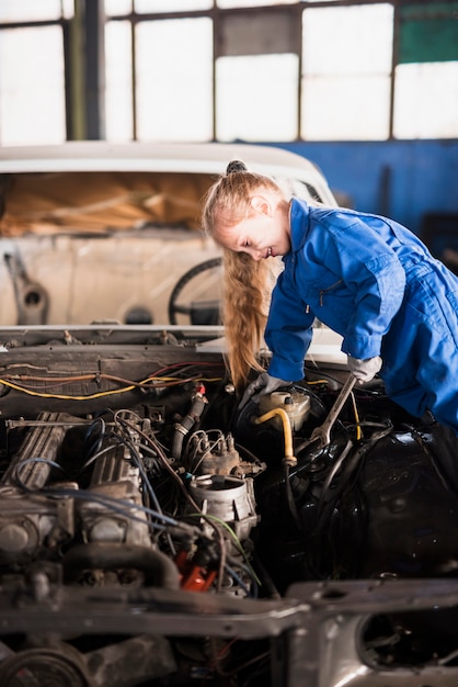 Little cute girl repairing car with spanner 