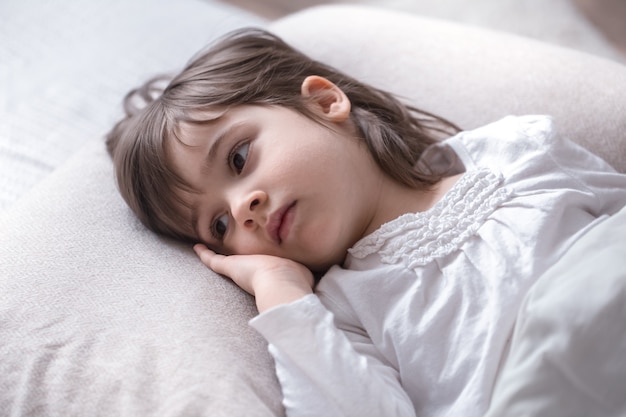 ベッドで悲しい小さなかわいい女の子、睡眠の概念