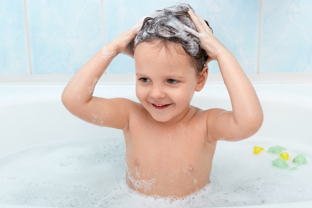 Free photo little cute girl taking bath, washing her hair with shampoo