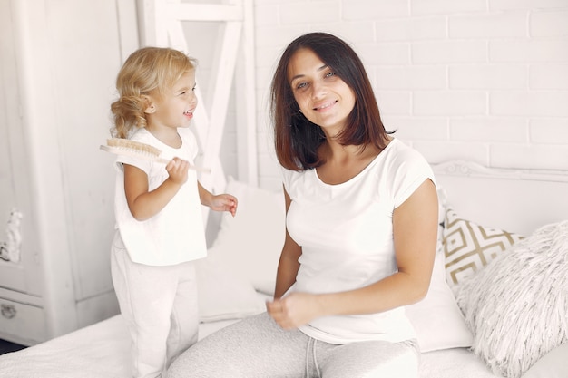 Little daughter combing her mom's hair