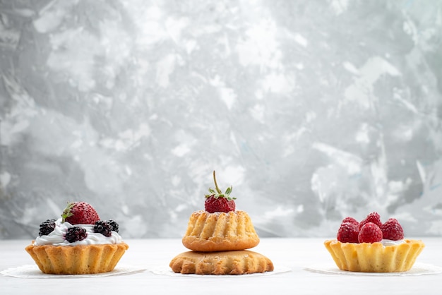 little delicious cakes with cream and berries on light , cake biscuit berry fruit sweet sugar