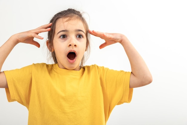 Free photo little desperate girl looking panic holding her head with both hands