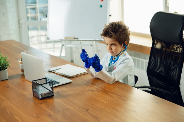 Little doctor during funny wearing protective gloves