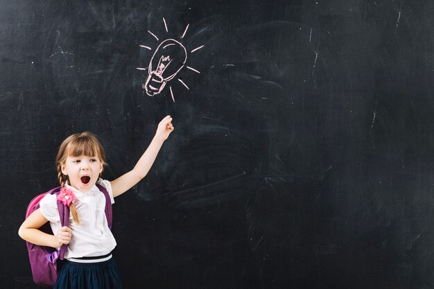 Little excited girl at blackboard