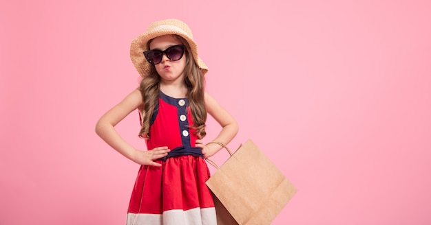 Free photo little fashionista on a colored background in mom's shoes