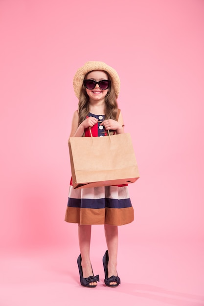 little fashionista on a colored background in mom's shoes