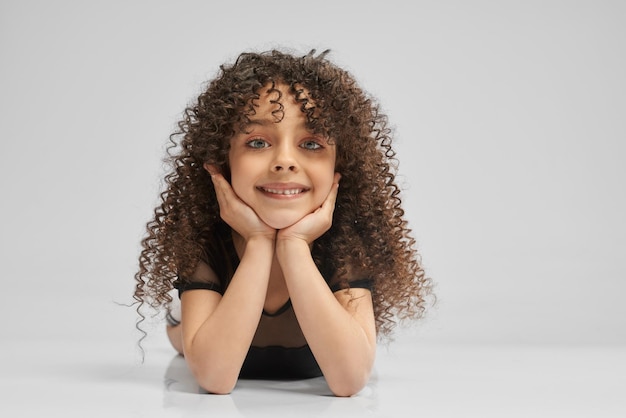 Free photo little female gymnast posing on studio floor