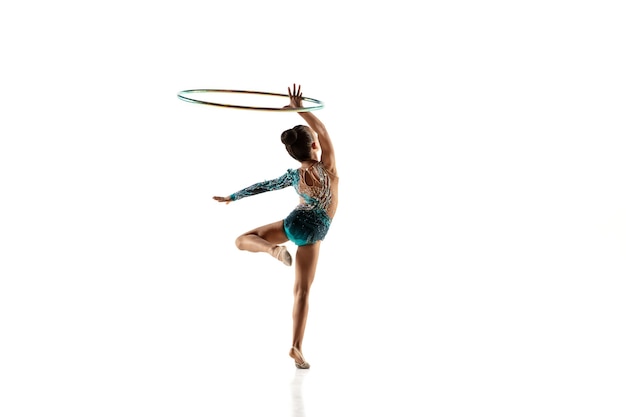 Little flexible girl isolated on white. Little female model as a rhythmic gymnastics artist in bright leotard.