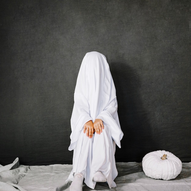 Бесплатное фото Маленький призрак возле белой тыквы