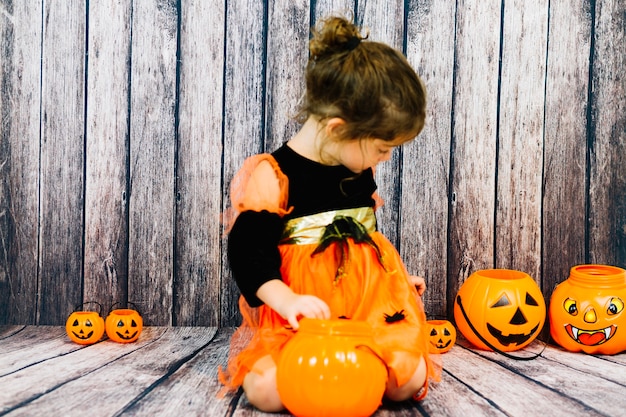 Little girl amidst pumpkins