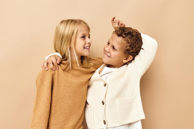 Маленькая девочка и мальчик обнимаются, игры улыбаются дружба студия эмоций. фото высокого качества