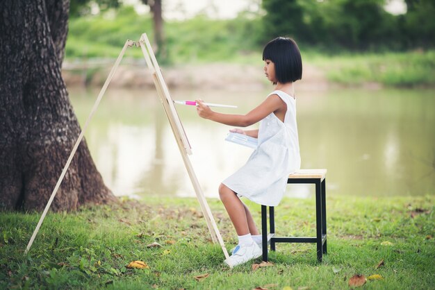 공원에서 작은 소녀 예술가 그림 그림