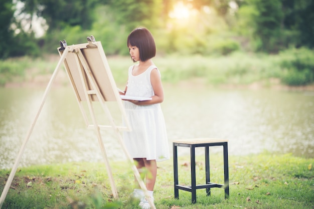 공원에서 작은 소녀 예술가 그림 그림