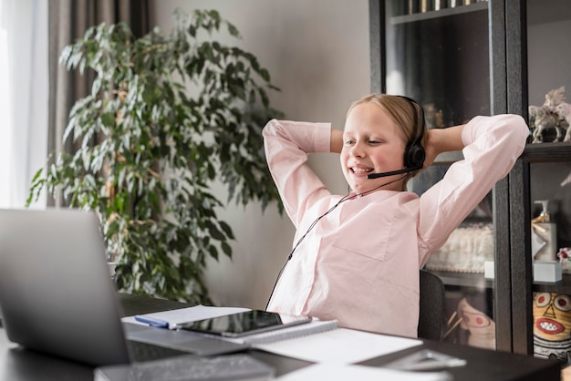 Bambina che è felice dopo aver finito la sua lezione online