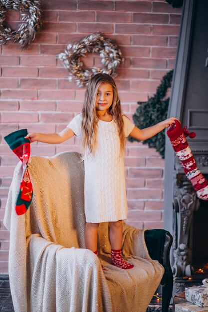 Little girl by christmas tree with christmas socks