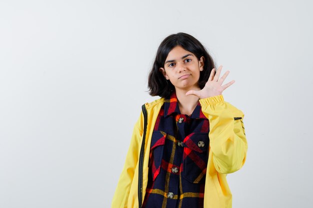 Little girl in checked shirt, jacket showing number five and looking confident , front view.