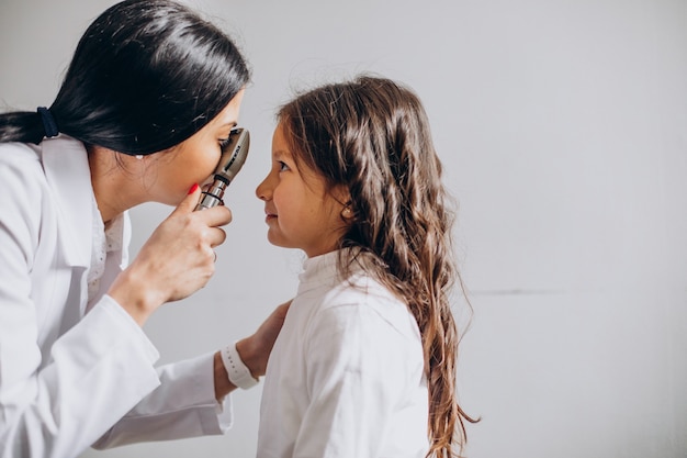 Маленькая девочка проверяет свое зрение в офтальмологическом центре