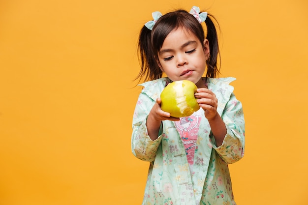 작은 여자 아이 먹는 사과.